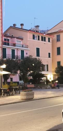 a large pink building with a table and chairs at Acquamarina in Rapallo