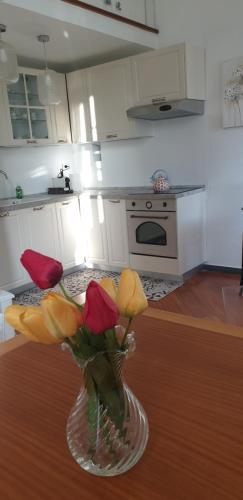 a vase with flowers sitting on a table in a kitchen at Acquamarina in Rapallo