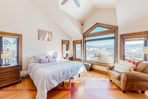 a bedroom with a bed and a chair and windows at Mountain Range Manor in Eagle