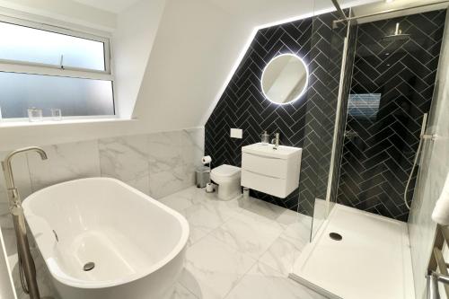 a bathroom with a sink toilet and a mirror at Tower House Apartments in Bournemouth