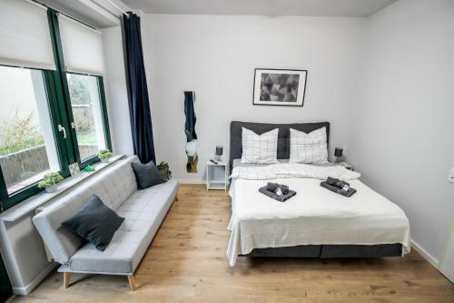une chambre avec un lit, un canapé et des fenêtres dans l'établissement Ferienwohnung Lorenz mit kostenlosem Parkplatz Netflix Boxspringbett Küche, à Magdebourg