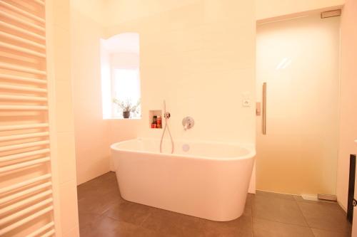 a white bath tub in a bathroom with a window at Villa Haag in Haag