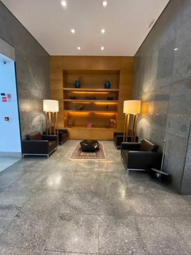 a lobby with two couches and a table and two lamps at Flat Perto de Tudo na Savassi in Belo Horizonte