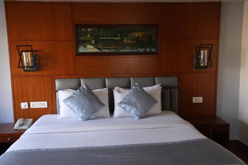 a bedroom with a bed with white sheets and pillows at Eastin Hotels- Madhapur in Hyderabad