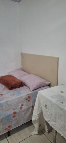 een bed in een kamer met een tafel ernaast bij KitnetdaNathy. in Itajaí