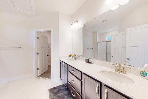 a bathroom with two sinks and a large mirror at The Waterside Gaming Retreat in Seaford