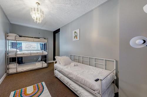 1 Schlafzimmer mit 2 Etagenbetten und einem Kronleuchter in der Unterkunft Riverside Retreat and Karaoke Oasis 