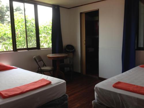 Santiago Este的住宿－EL-CACIQUE-guesthouse-since-2003，客房设有两张床、一张桌子和窗户。