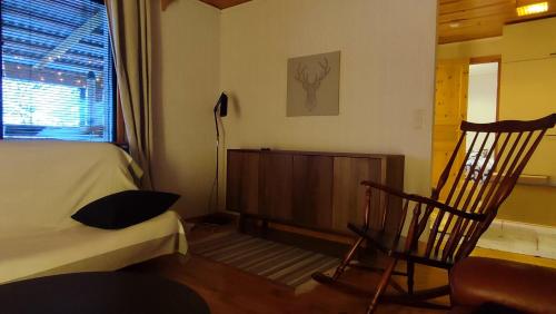 a bedroom with a bed and a chair and a window at Le Paradis Blanc Sauna & Spa in Kortetniemi