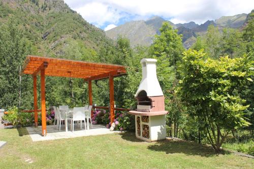 a backyard with a pizza oven and a gazebo at Villa Giuly in Antronapiana