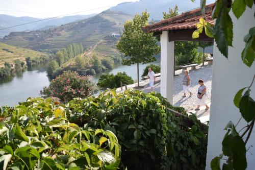 a view of a river with people walking by a building at Quinta do Tedo in Folgosa