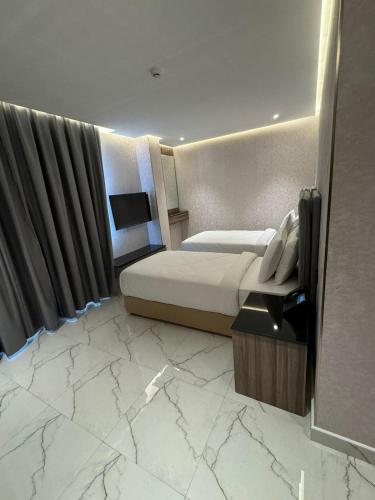 a hotel room with a bed and a television at Royal Plaza Hotel in Duqm