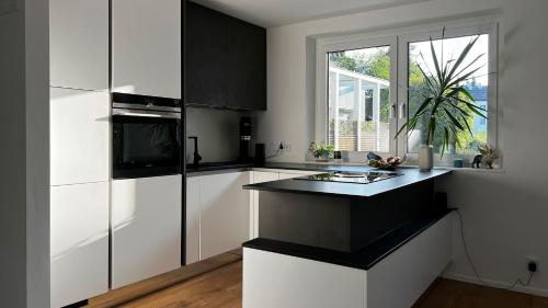 a kitchen with white cabinets and a black counter top at Helle Wohnung in Top Lage! in Linz