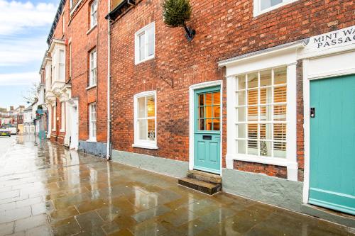 ceglany budynek z niebieskimi drzwiami na deszczowej ulicy w obiekcie 31 Bailgate Lincoln w mieście Lincolnshire