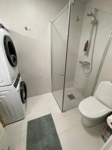 een badkamer met een douche en een toilet bij Ny lägenhet på markplan med havsutsikt in Strömstad