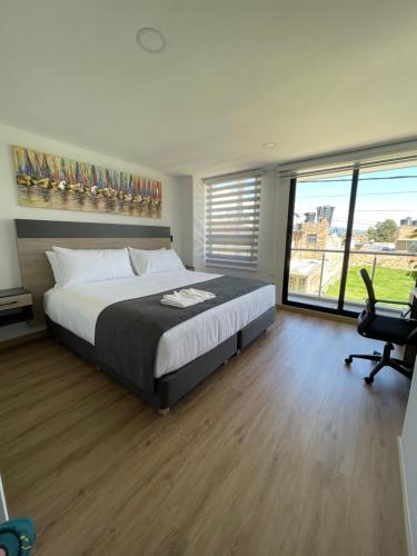 1 dormitorio con cama, escritorio y silla en HOTEL SALVATORE, en Paipa