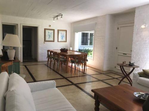 uma sala de estar com mesa e cadeiras em Casa de 6 ambientes a 2 cuadras de la playa brava em Punta del Este