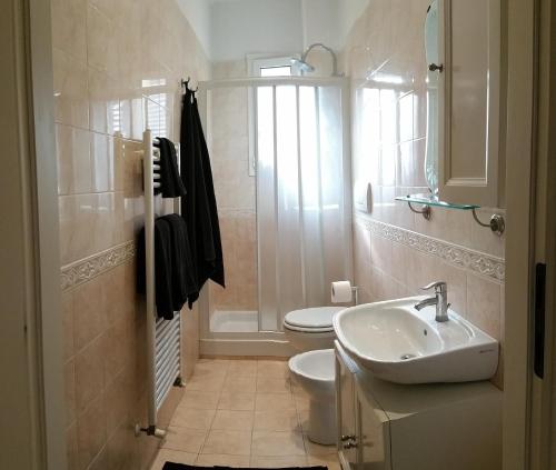a bathroom with a sink and a toilet and a window at Fuori Portico Unità in Bologna