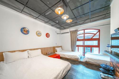 羅東鎮的住宿－羅東夜市 工業Loft旅宿 Loft House，一间卧室设有两张床和窗户。