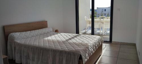 une chambre avec un lit et un balcon dans l'établissement Grand T2 neuf classé 3 étoiles, à Porticcio