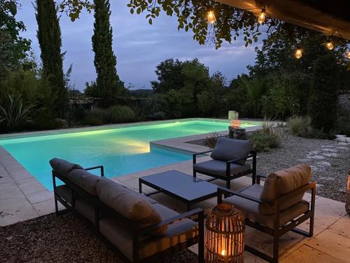 einen Pool mit einem Sofa, 2 Stühlen und einem Tisch in der Unterkunft calme et repos garantis au cœur des vignes Charentaises in Échallat