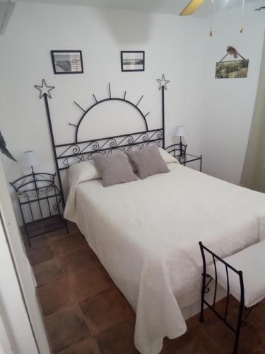 1 dormitorio con 1 cama blanca grande con cruces en la pared en atico centrico nervion, en Sevilla