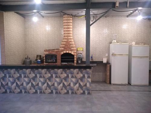 eine Küche mit einem Steinofen und 2 Kühlschränken in der Unterkunft espaço 16 in Maricá