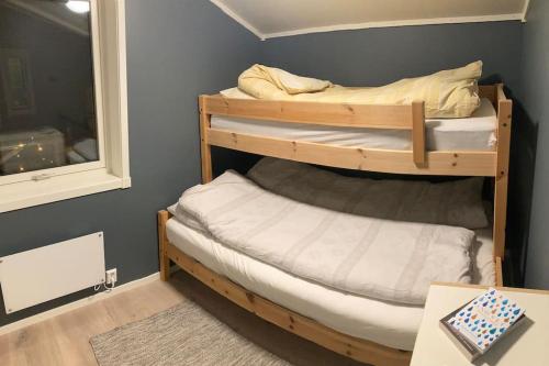 two bunk beds in a room with a window at All new, fully equipped apartment at the gate of Senja 