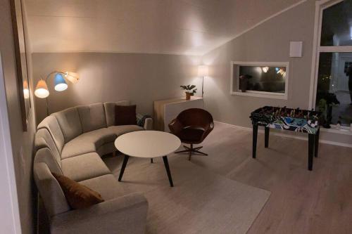 een woonkamer met een bank en een tafel bij All new, fully equipped apartment at the gate of Senja 