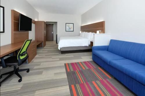 a hotel room with a bed and a blue couch at Holiday Inn Express - Minneapolis West - Plymouth, an IHG Hotel in Plymouth