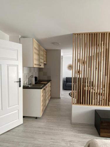 a kitchen with white cabinets and a white door at Morska Kryjówka in Niechorze