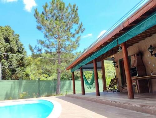 een huis met een zwembad naast een hek bij Casa completa em meio à natureza in Passa Quatro