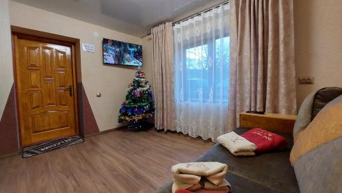 a living room with a christmas tree next to a door at ЗОЛОТА РИБКА in Slavske