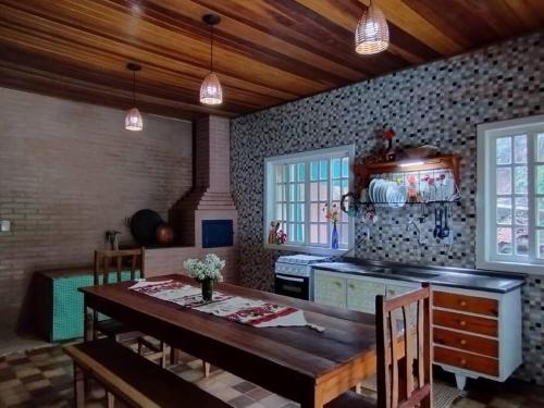 een keuken met een houten tafel en een fornuis bij Casa completa em meio à natureza in Passa Quatro
