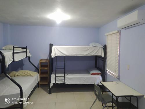 a room with two bunk beds and a table at Casa para grupos hasta de 20 personas Frente al parque industrial Zilum Park Crown Iberdrola hunter Douglas in Dulces Nombres