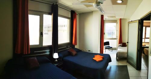プエルト・デル・ロサリオにある2V LUXURY APARTMENT NEAR BEACHのベッドルーム1室(青いベッド1台、窓2つ付)