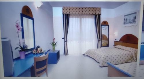 1 dormitorio con cama, escritorio y mesa en Akiris, en Nova Siri Marina