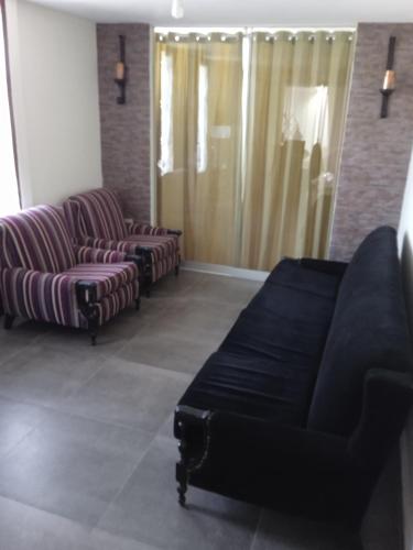 un soggiorno con 2 sedie e un divano di Casa Villa Eru a Gallinazos Hacienda