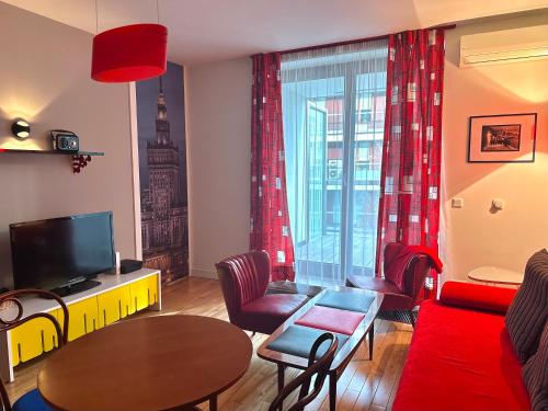 a living room with a red couch and a table at Project Comfort Leszczyńska 4/33 Warszawa in Warsaw