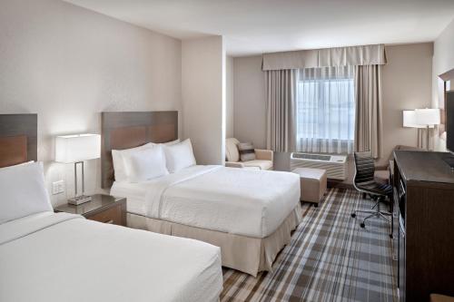 a hotel room with two beds and a desk at Fairfield Inn & Suites by Marriott Airdrie in Airdrie