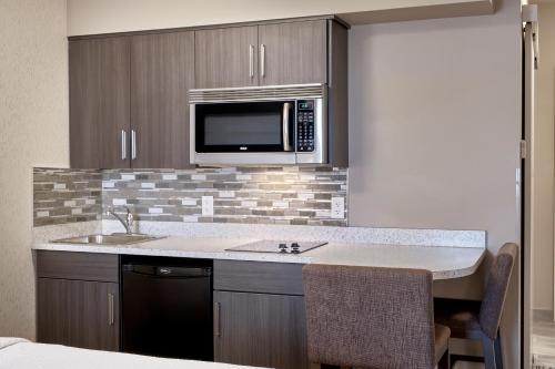a kitchen with a sink and a microwave at Fairfield Inn & Suites by Marriott Airdrie in Airdrie
