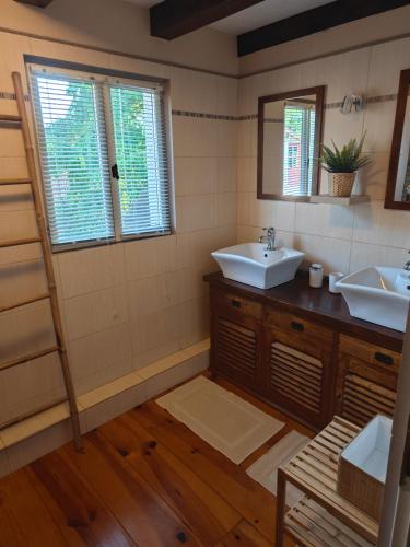 a bathroom with two sinks and two mirrors at Gîte du Mas de Palaille 8 Personnes in Salvagnac-Cajarc