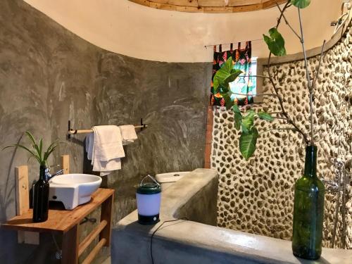 a bathroom with a sink and a bath tub at Queen Elizabeth Gorge Cottages in Rubirizi