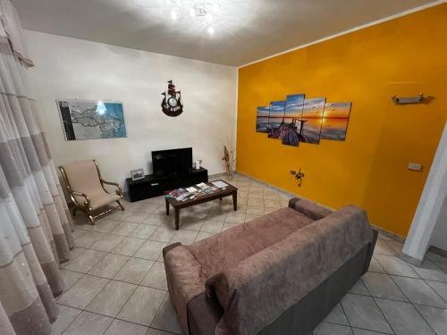 a living room with a couch and a yellow wall at Casa Giulia in Santa Giulia