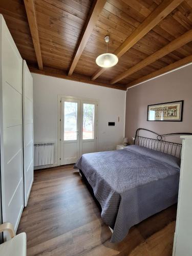 a bedroom with a bed and a wooden ceiling at Case Vacanza Pianoneve in Buseto Palizzolo
