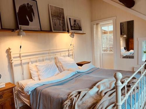 1 dormitorio con cama blanca y almohadas en Cozy cottage with sea view, en Svenshögen