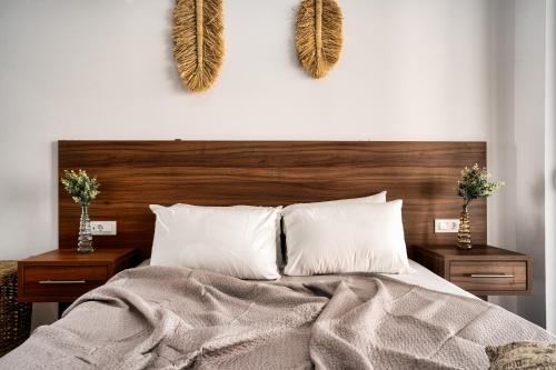 a bedroom with a bed with two night stands and two vases at Violet Beach Front Private Villa in Laganas