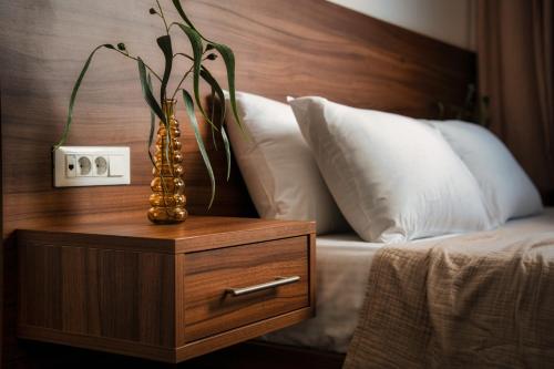 a vase on a night stand next to a bed at Violet Beach Front Private Villa in Laganas
