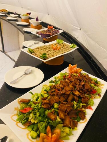 a table with several plates of food on it at Julia Rum Luxury Camp in Wadi Rum