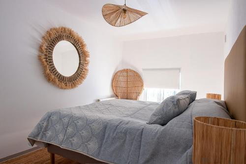 Schlafzimmer mit einem Bett und einem Wandspiegel in der Unterkunft Casa Molar in Altea